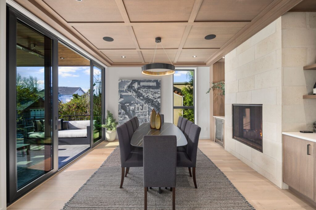 Madison Park Dining Room - white oak paneling with pass-through fireplace and limestone surround for new construction home in Seattle